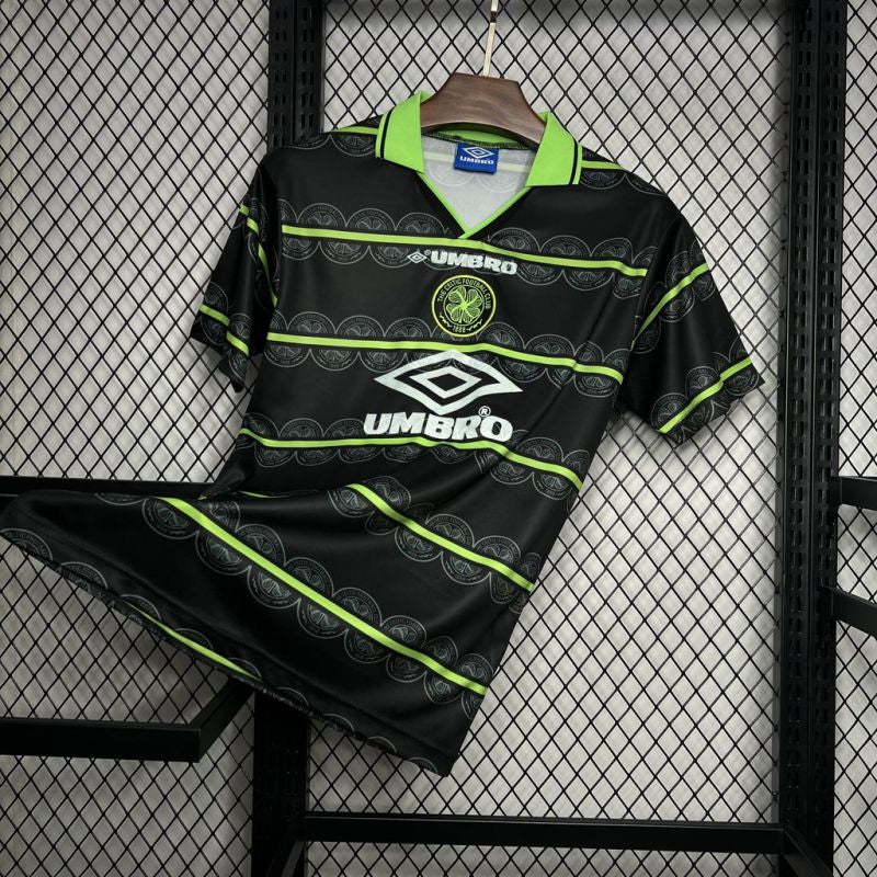 Celtic FC Umbro football shirt angled on a display rack, highlighting the front design and neon green accents.