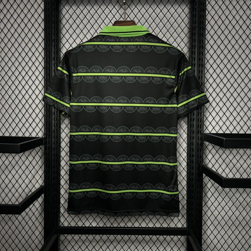 Back view of the Celtic FC Umbro shirt, displaying the repeating patterned design and green trim on the collar and sleeves.