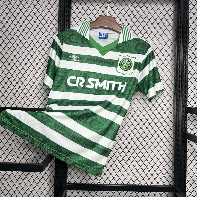 Full view of the 95 Celtic FC home shirt and shorts set hanging on a rack, displaying the green and white hoops and club details