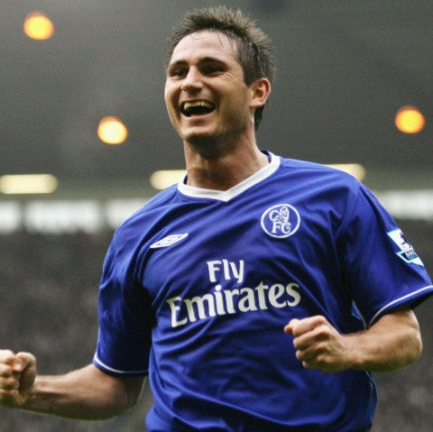 Frank Lampard celebrating in a blue 2003 Chelsea kit with white Fly Emirates sponsor logo, Umbro logo, and retro club crest, on a football pitch.