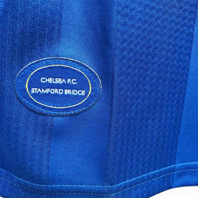 Detail of the lower front of a Chelsea FC 1999-2001 home shirt, showing the "Chelsea F.C. Stamford Bridge" stitched badge.