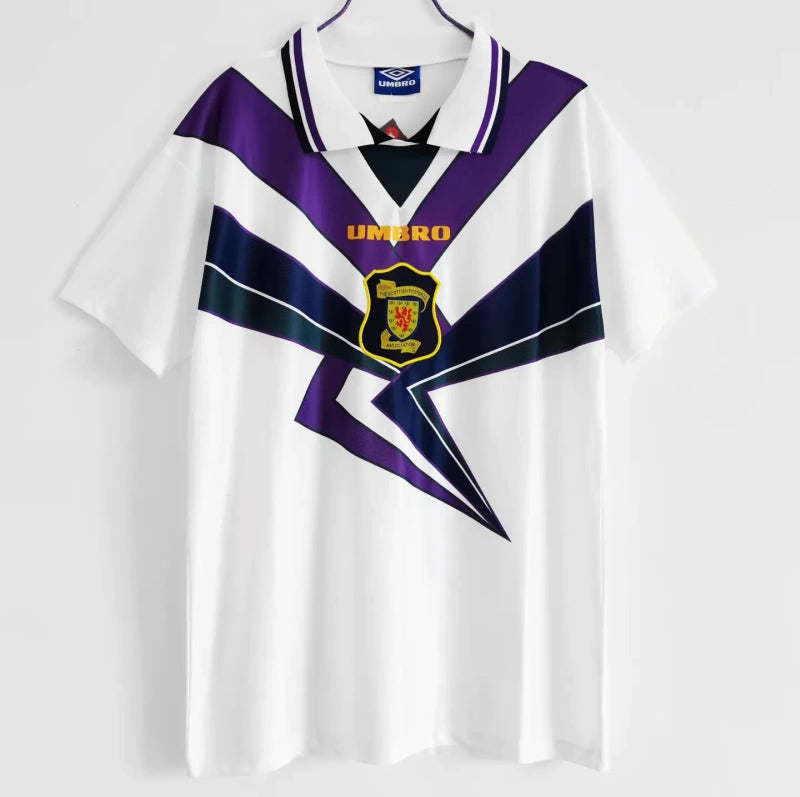Front view of a white 1994 Scotland football shirt by Umbro, featuring bold purple and navy geometric patterns, a collared neckline, and the Scottish Football Association crest on the chest.