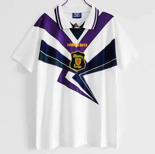 Front view of a white 1994 Scotland football shirt by Umbro, featuring bold purple and navy geometric patterns, a collared neckline, and the Scottish Football Association crest on the chest.