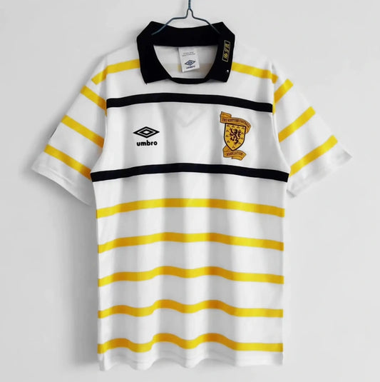 Front view of a vintage 1990 Scotland football shirt by Umbro, featuring yellow and black stripes, a black collar, the Umbro logo, and the Scottish Football Association crest.