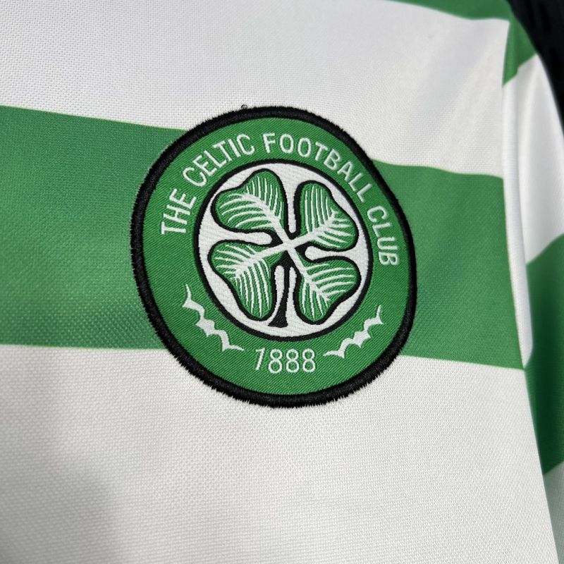 Close-up of the Celtic FC club crest with a four-leaf clover and '1888' on a green and white hooped football shirt