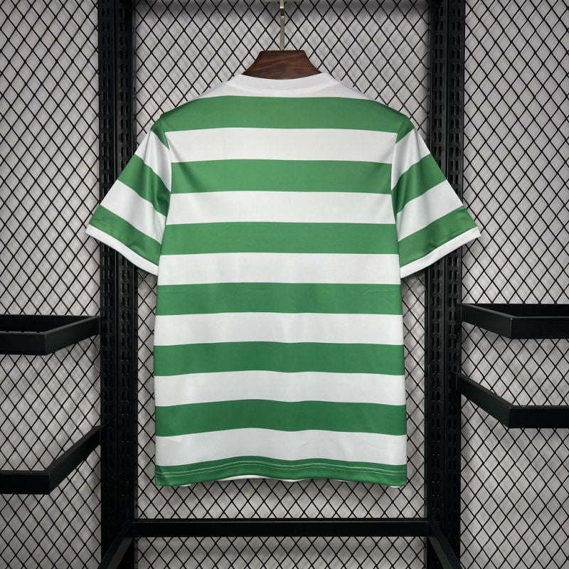 Back of Celtic FC 1980 green and white hooped Umbro football shirt hanging on a wooden hanger against a mesh background