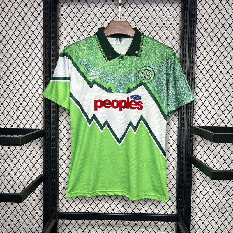 Celtic FC 1991-1992 away football shirt by Umbro with green, white, and dark green zig-zag design, "peoples" Ford sponsor, and club badge on the chest, displayed on a hanger.